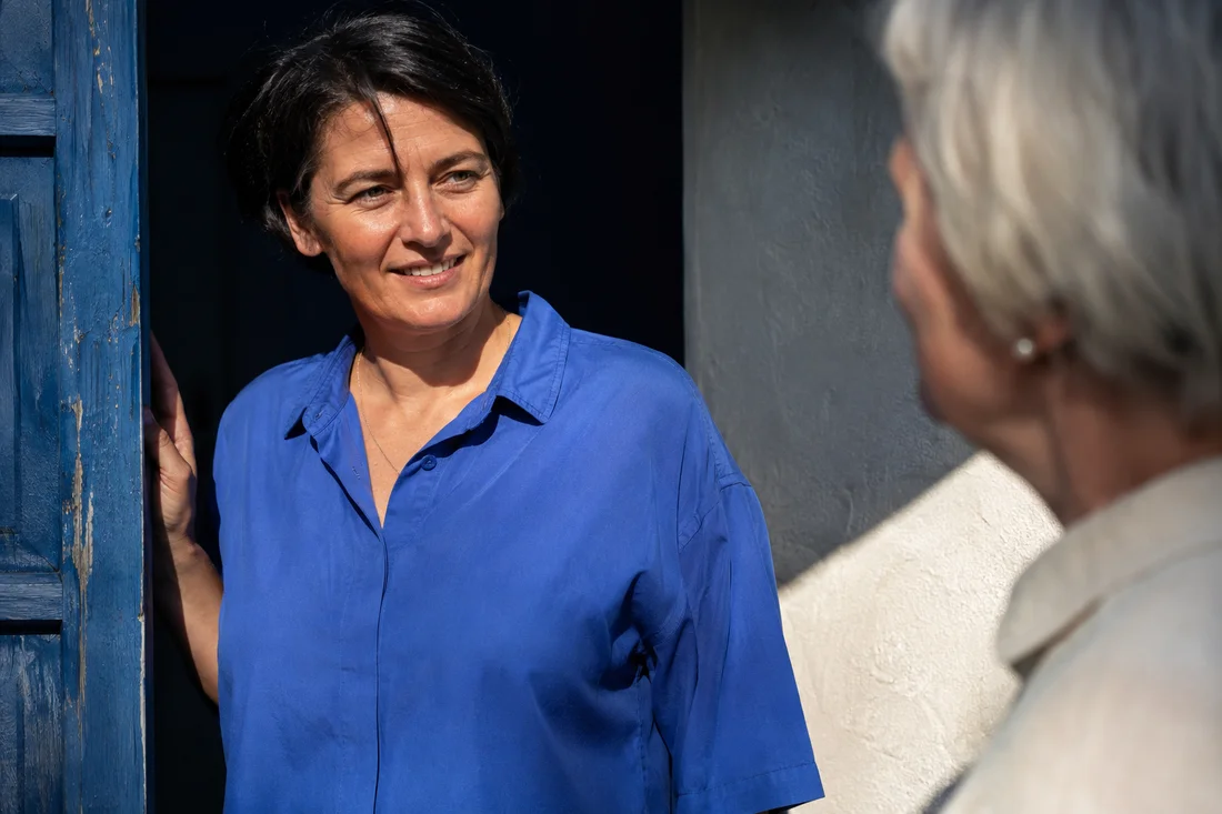 Eine Frau hört ihrer Gesprächspartnerin aufmerksam zu. KI-generiertes Bildmotiv.